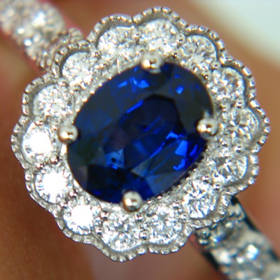 white gold and diamonds around an oval no-heat rich blue sapphire in blossom setting