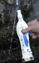 Our Lady of Lourdes bottle being filled at the Grotto